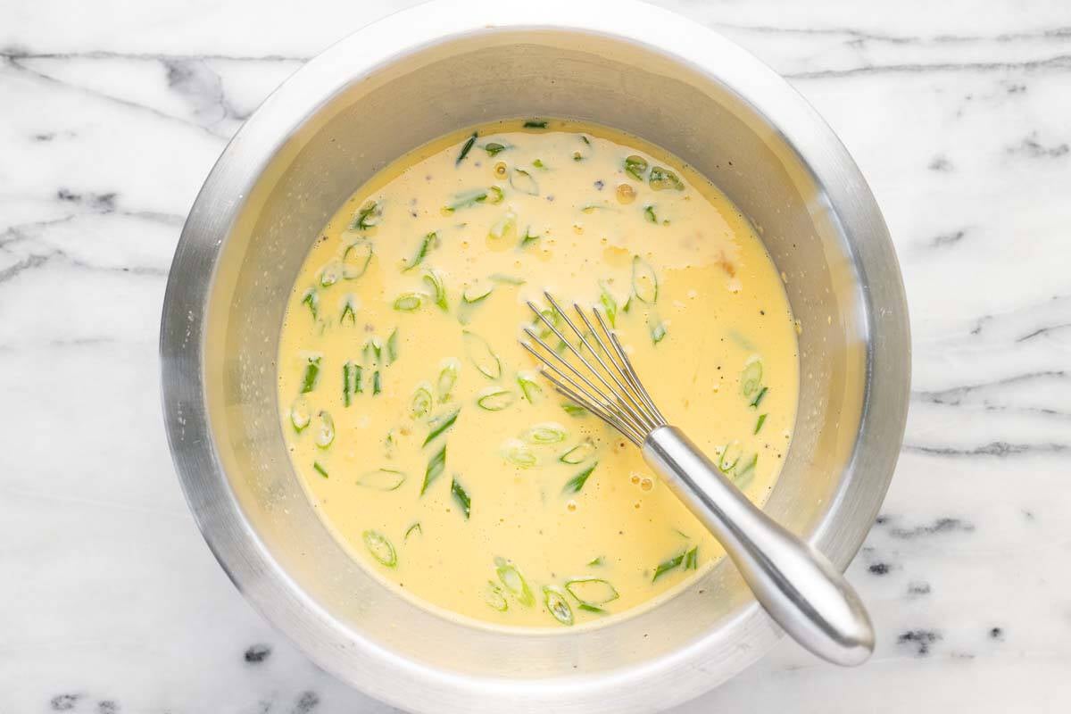 Bowl filled with egg casserole ingredients.