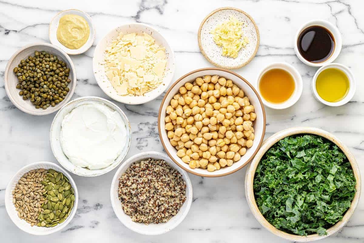 Bowls of ingredients to make dense bean Caesar salad.