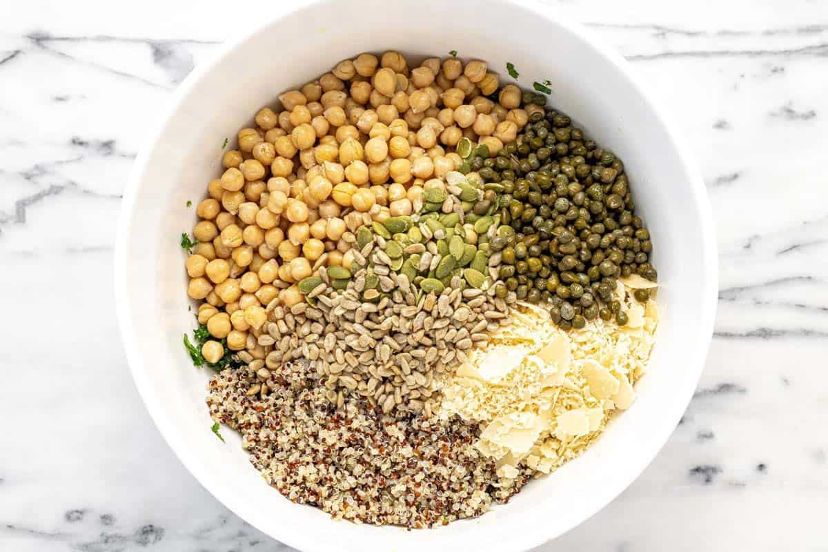 Large bowl filled with ingredients to make dense bean Caesar salad.