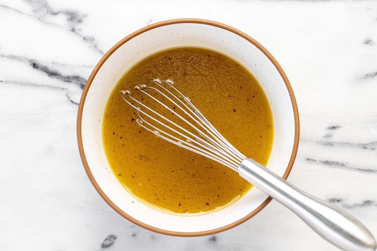 Bowl of sesame dressing with a whisk.