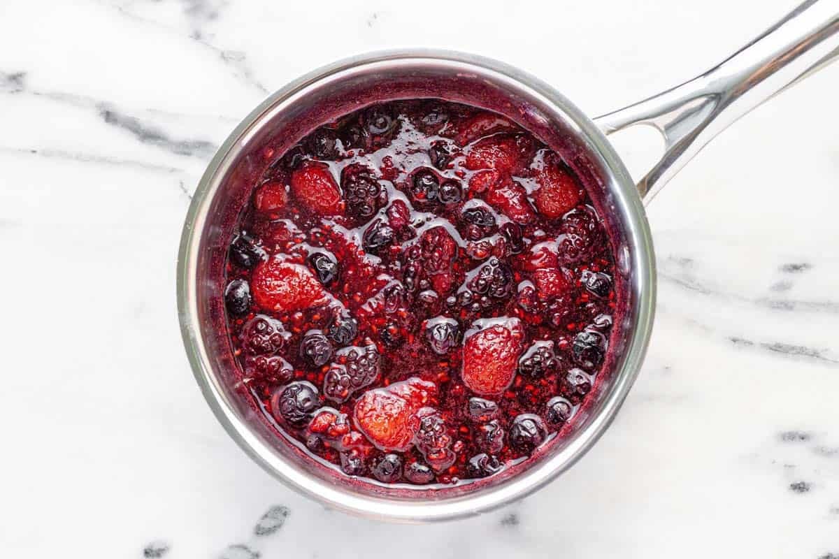 Cooked berry compote in a small saucepan.