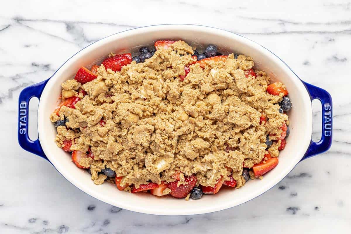 Homemade berry crumble in a baking dish, ready for the oven.