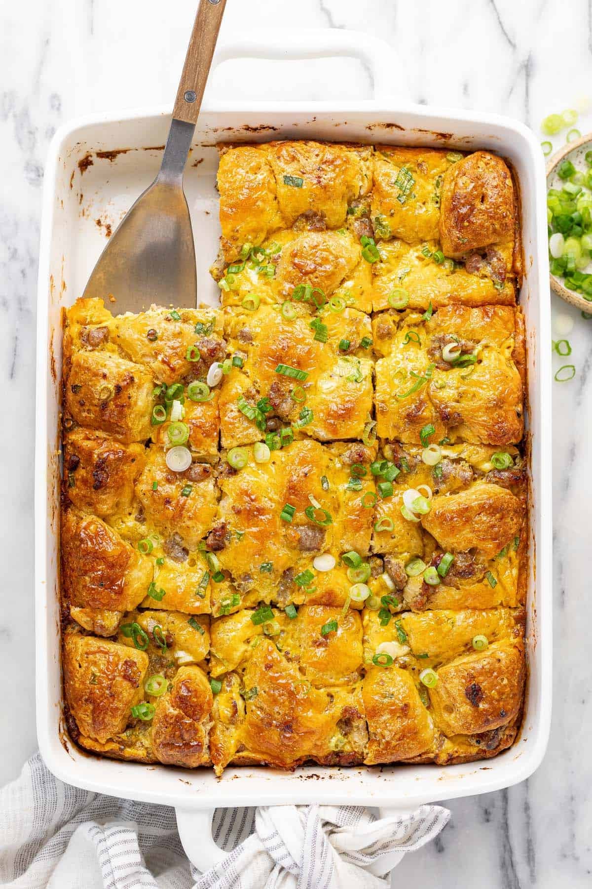Large baking dish filled with biscuit breakfast bake garnished with green onion.