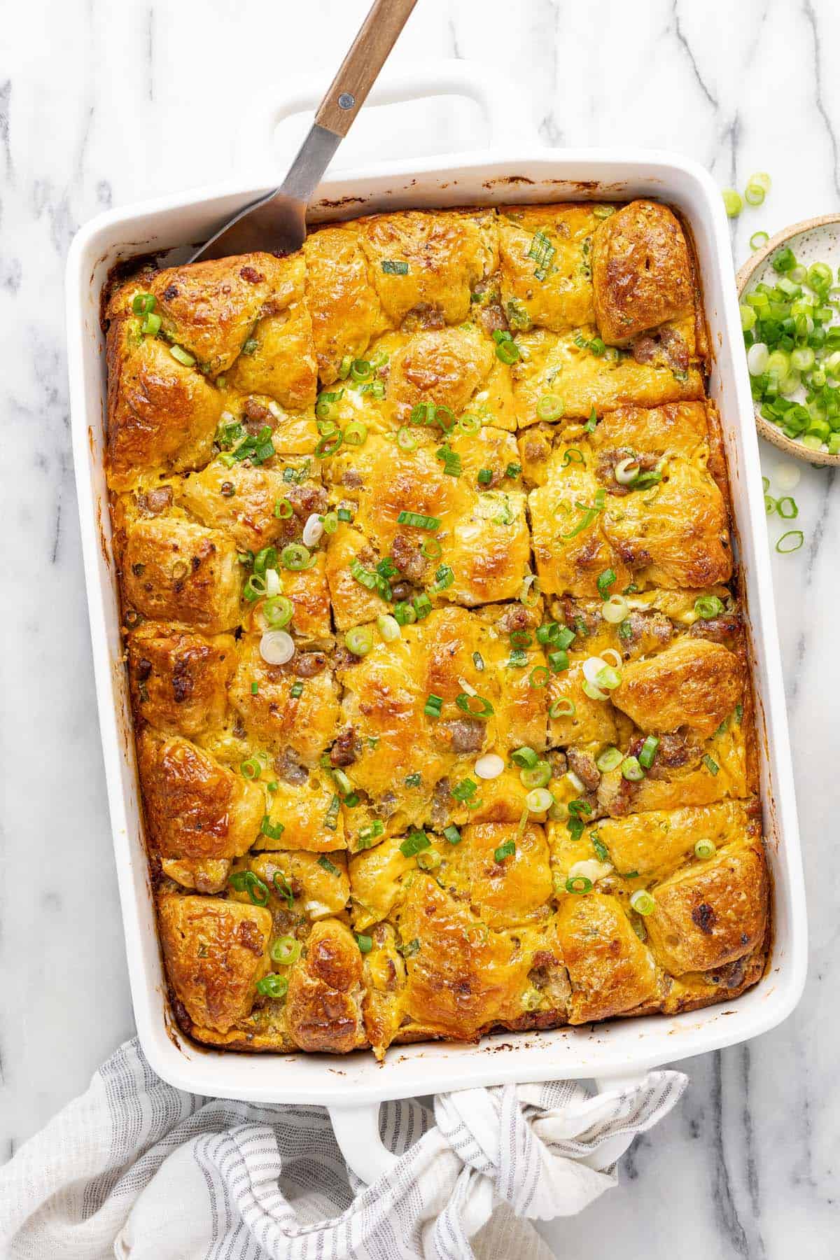 Large baking dish filled with biscuit breakfast bake garnished with green onion.