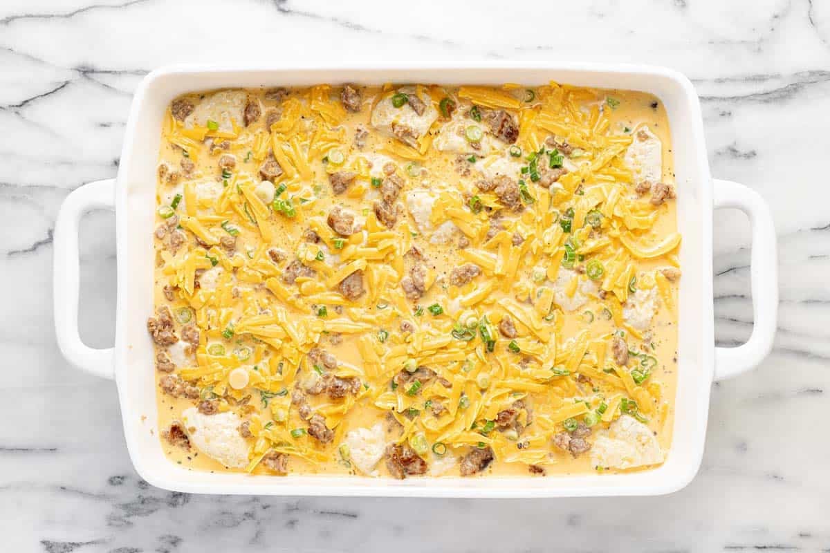 Baking dish filled with everything to make a biscuit breakfast bake.