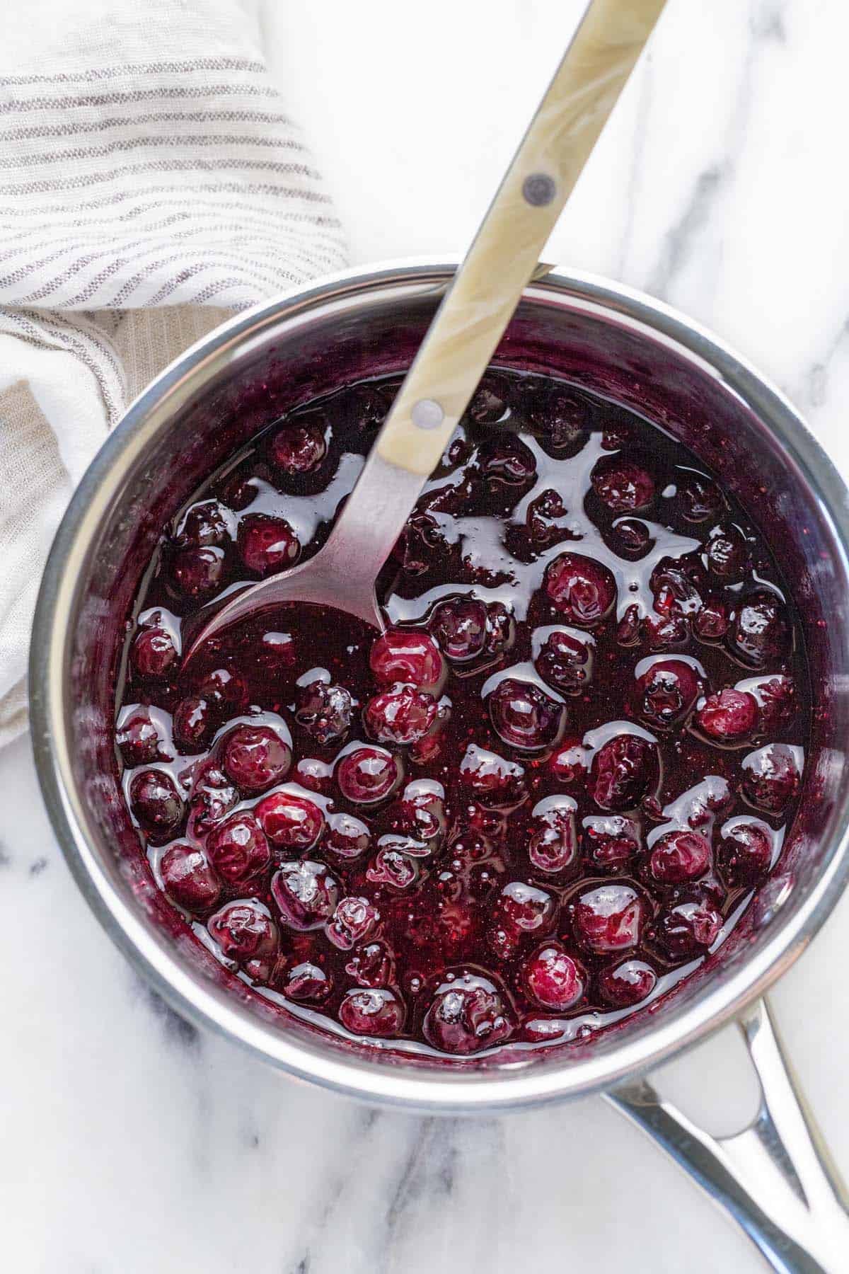 Small saucepan filled with homemade blueberry compote.