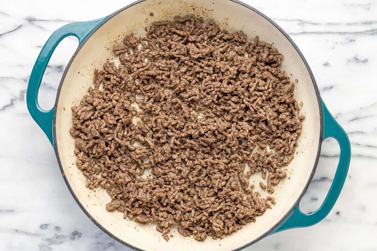 Large pan filled with cooked ground beef.