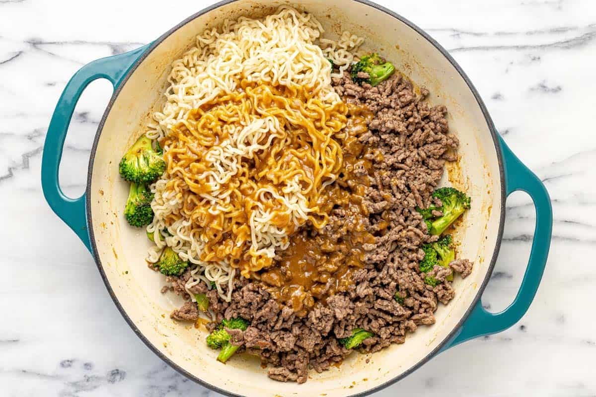 Large pan filled with ground beef, ramen noodles, and broccoli.