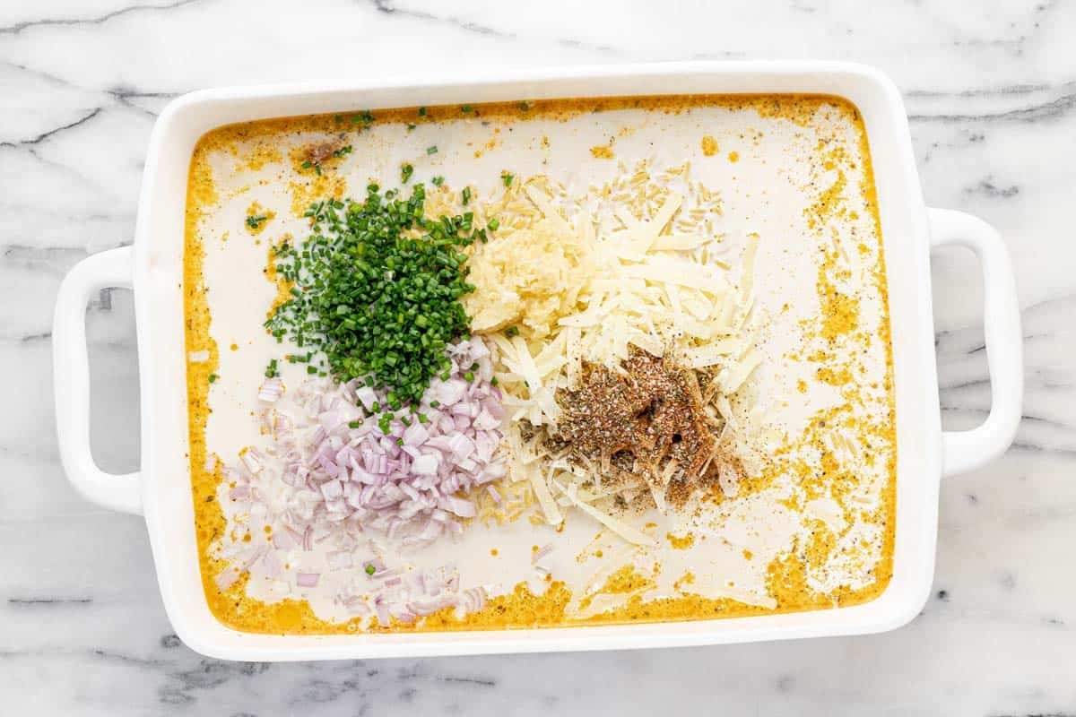 Baking dish filled with ingredients to make baked chicken and orzo.