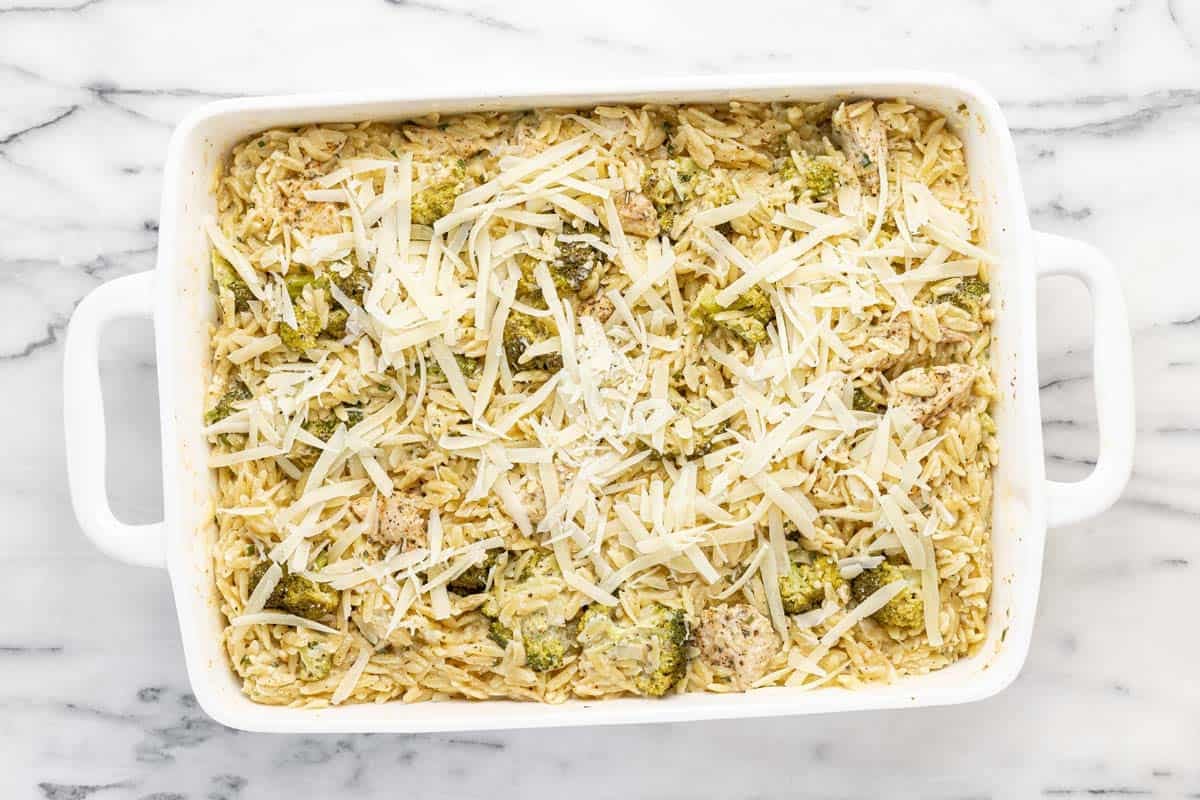 Shredded cheese on top of chicken and orzo casserole.