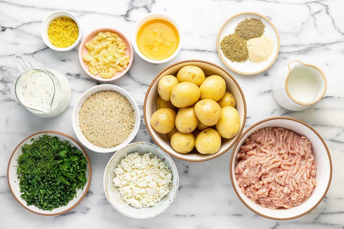 Bowls of ingredients to make Greek chicken meatballs.