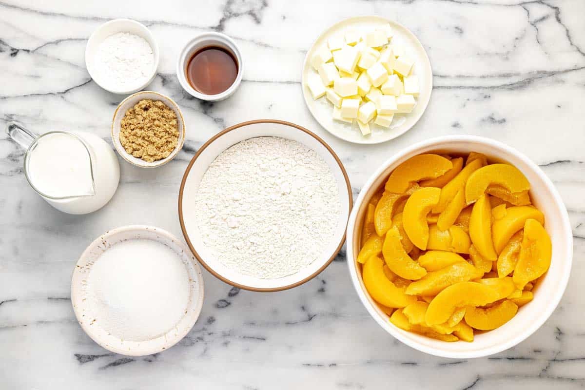Bowls of ingredients to make peach cobbler.