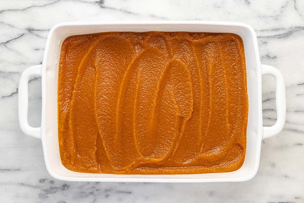 Pumpkin dump cake filling in a large 9x13 pan.