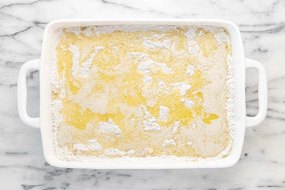 Butter drizzled over the sprinkled cake mix.