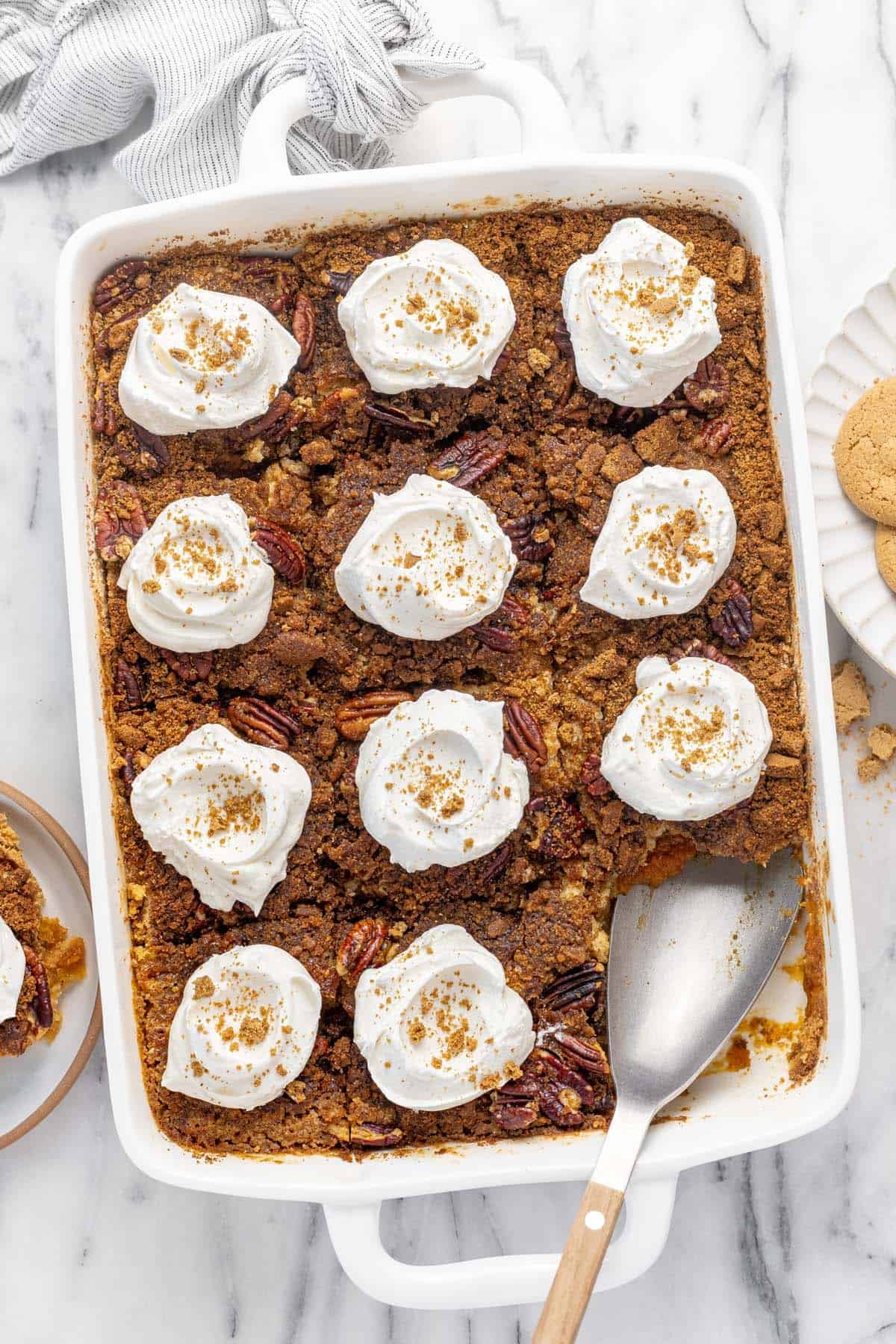 Large pan filled with pumpkin dump cake topped with Cool Whip.
