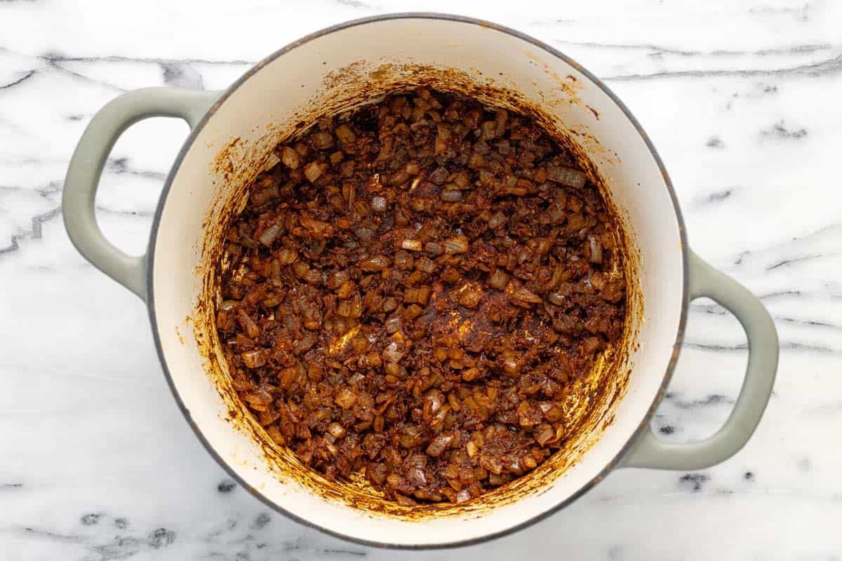 Onions, garlic, spices, and tomato paste cooked in a large pot.